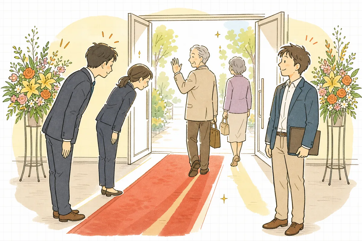 式典が終わったホールの入口で、帰る来賓に見送りの礼をしているスタッフと、その後ろで安堵の表情を浮かべている制作ディレクター